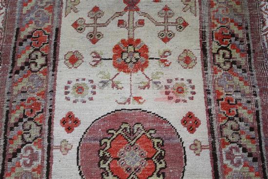 An Antique Khotan rug, with stylised floral motifs on a cream ground, multi-bordered, 145 x 75cm